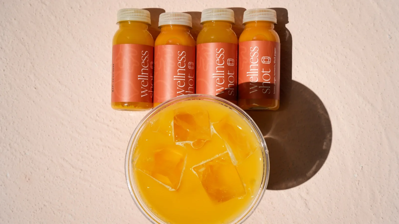 Bottled fruit drinks arranged beside a glass of orange juice
