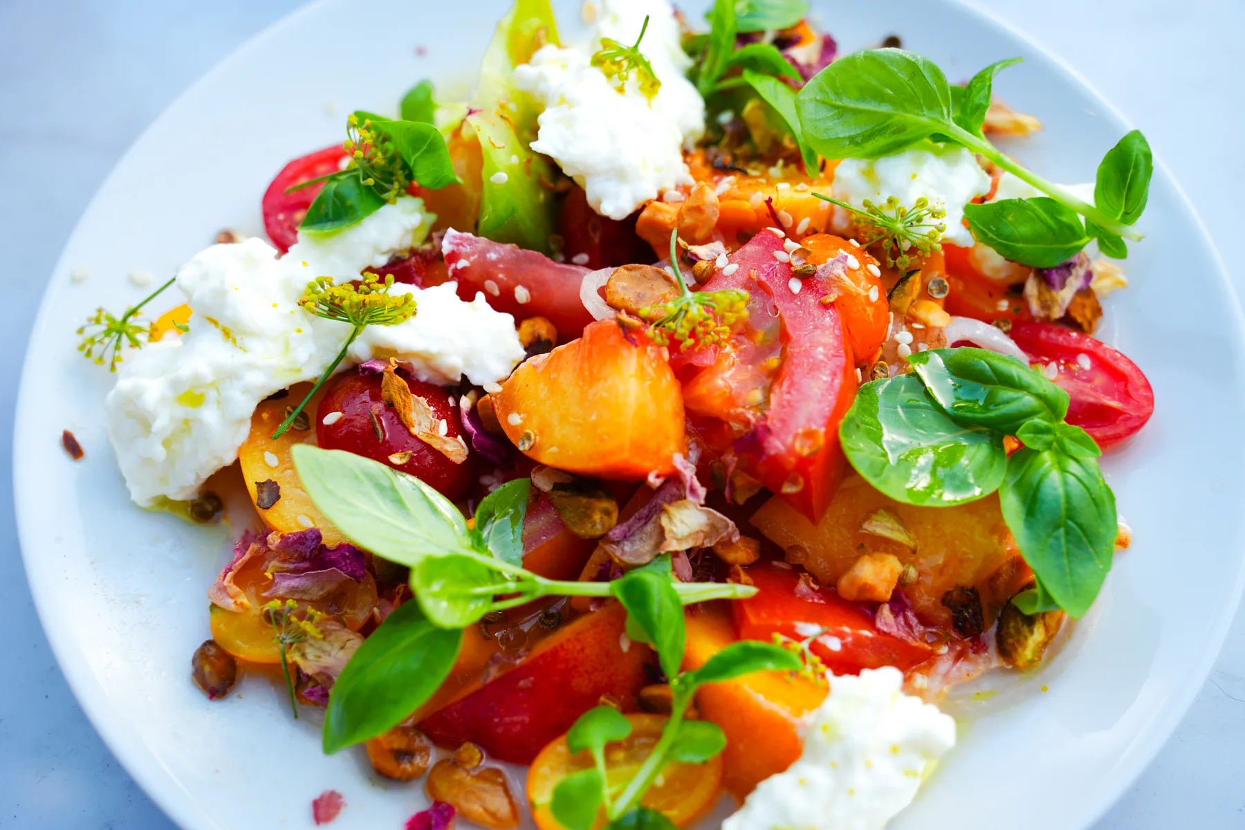 Brightly colored salad plated with herbs and vegetables